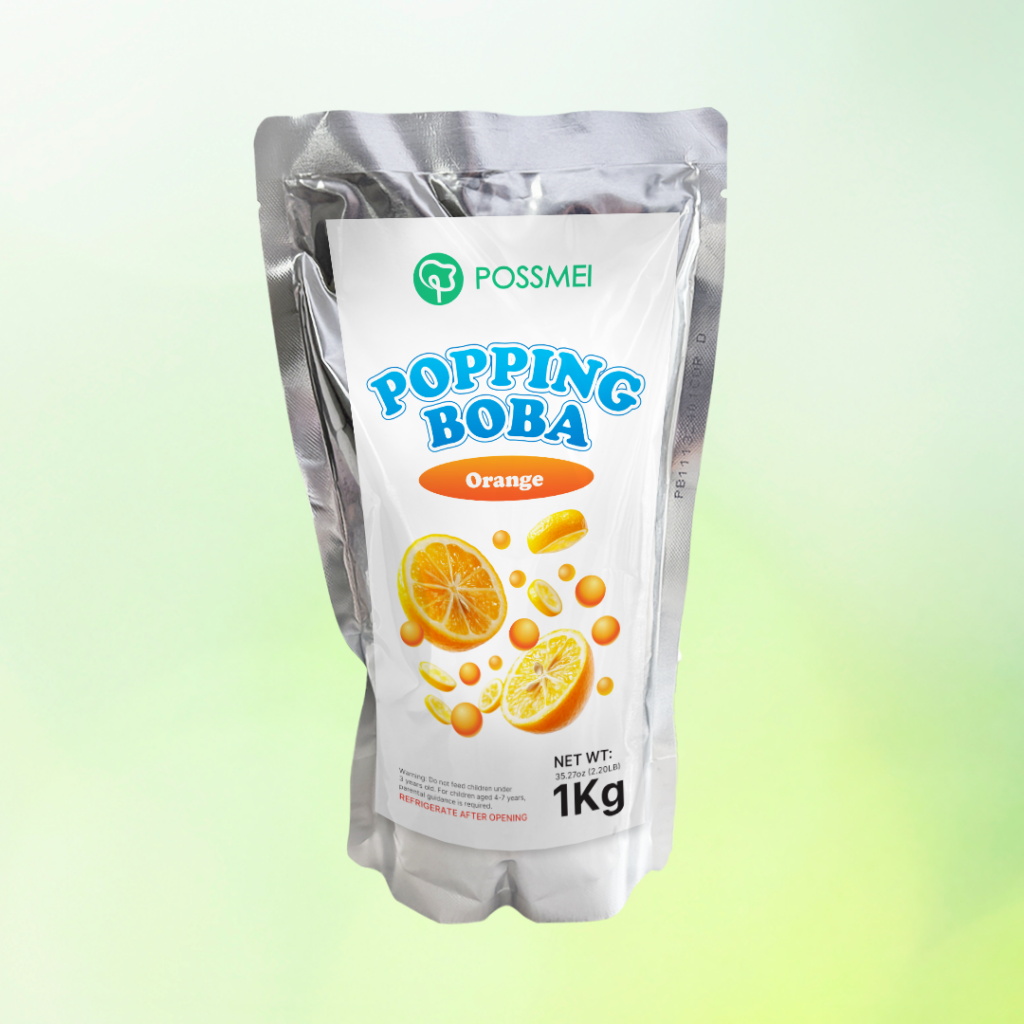 Possmei popping boba orange flavor in a 1kg silver pouch with fresh citrus design on a light green background.