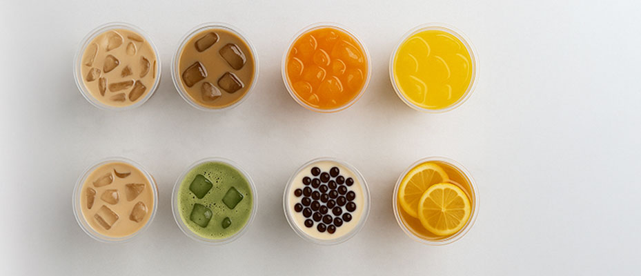 Top view of eight ProPossmei-crafted drinks in plastic cups, featuring milk teas, matcha, fruit teas, and pearls on a white table.