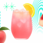 A chilled glass of Fyzzie Pink Peach Lemonade served with ice cubes and a lemon slice, with fresh peach accents around the drink.