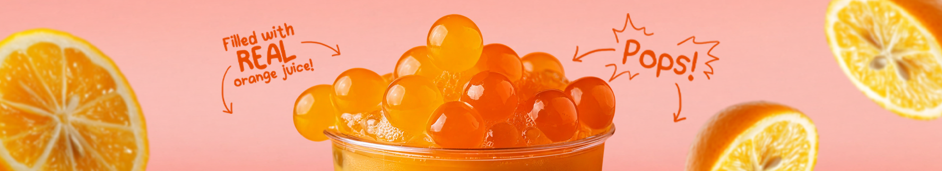 Close up of orange popping boba Philippines on top of a refreshing drink, filled with real orange juice and highlighted with playful text Pops against a pink background.
