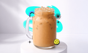 A creamy Bubble Tea Wintermelon Recipe drink in a mason jar with ice placed on a white podium with a bright aesthetic background