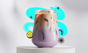 A creamy dreamy taro milktea in a clear cup with rich purple color, topped with milk foam and served cold
