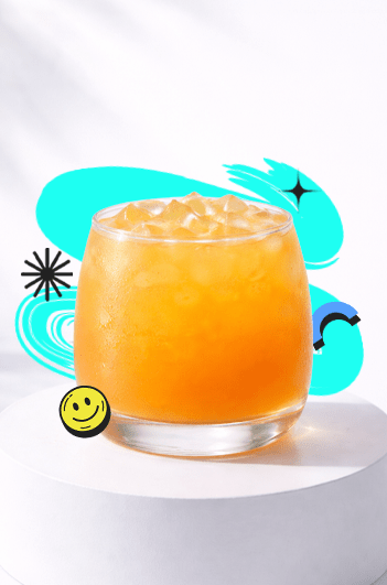 A refreshing Iced Mango Peach drink in a short round glass with ice placed on a white podium with a bright aesthetic background